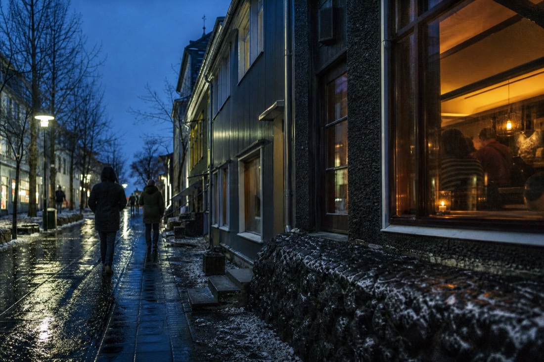 Reykjavik bar interior at night with warm window light and figures blurred at the back