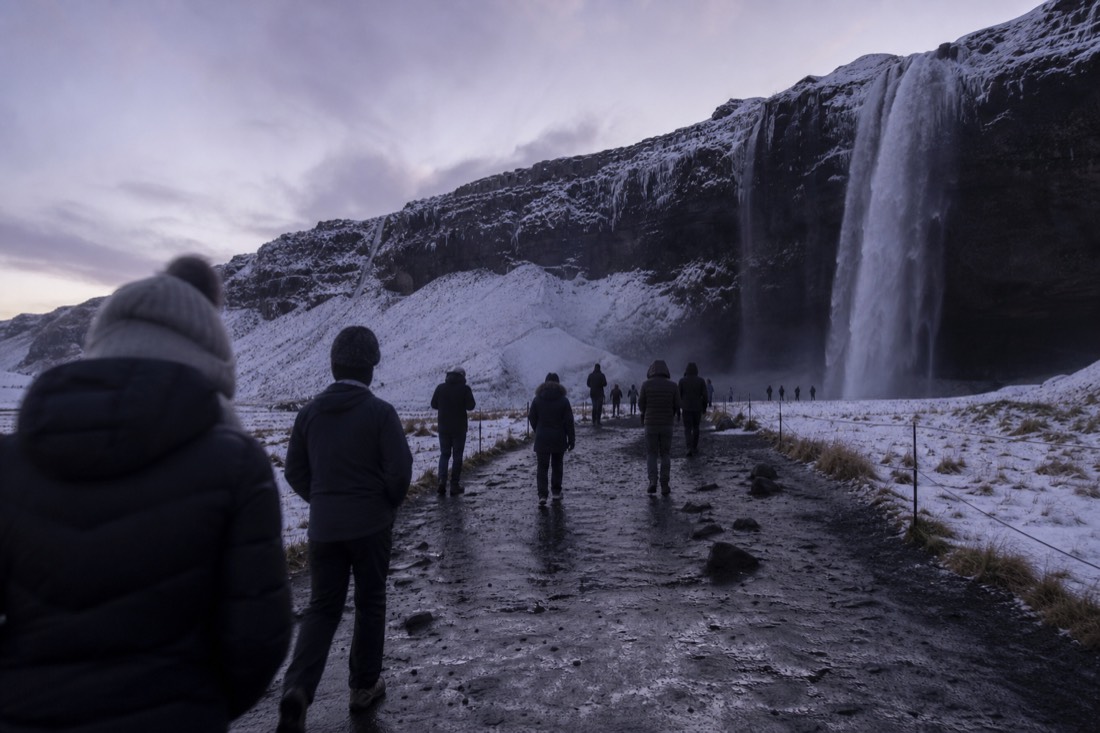 A minibus group at Seljalandsfoss on a small-group South Coast tour from Reykjavík