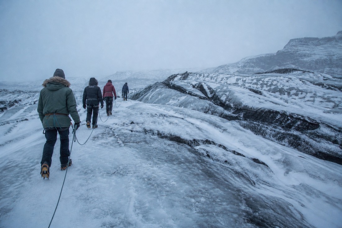 A roped group in crampons on a glacier hiking tour on Sólheimajökull in winter