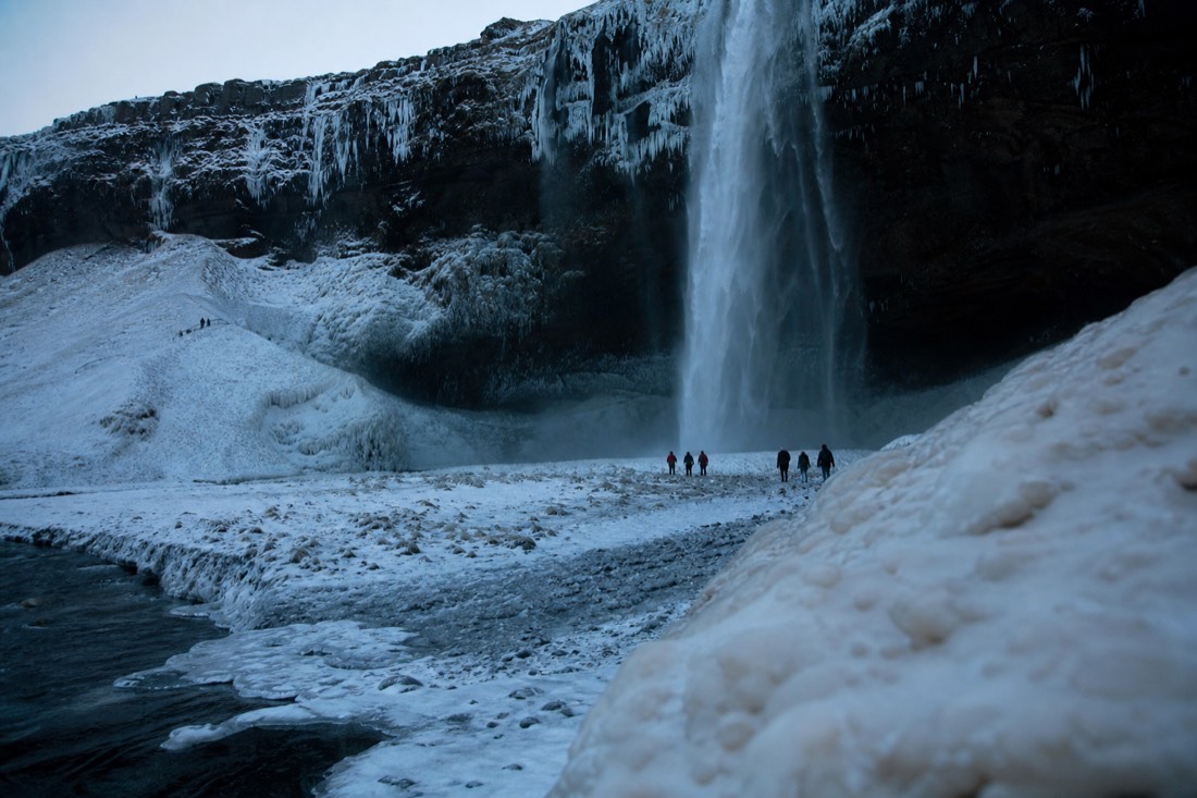 Seljalandsfoss waterfall framed by ice on a South Coast winter tour from Reykjavík