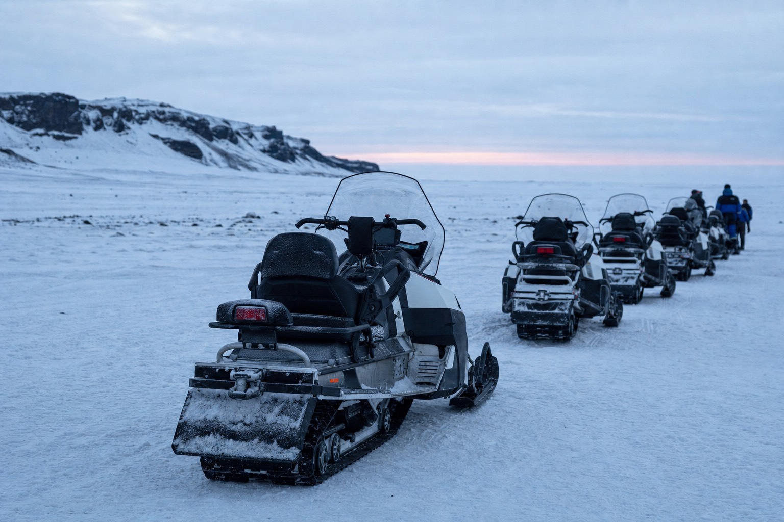 Snowmobiles lined up on the white surface of Langjökull glacier on an Iceland winter tour