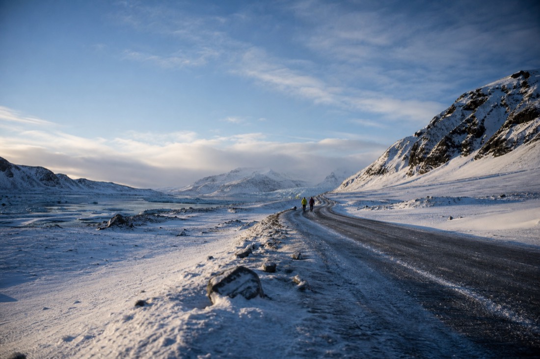Late February afternoon sun on a snowy south Iceland valley road, long blue shadows