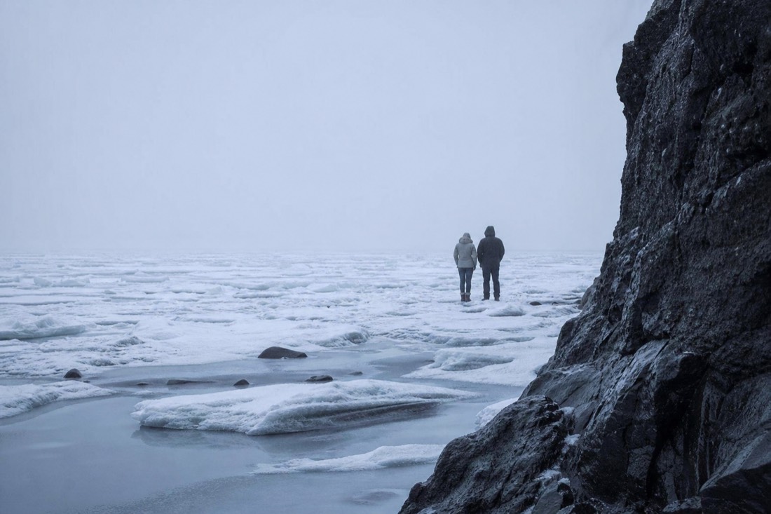 Overcast flat light on a frozen lake near Reykjavik, pale snow and no visible horizon line