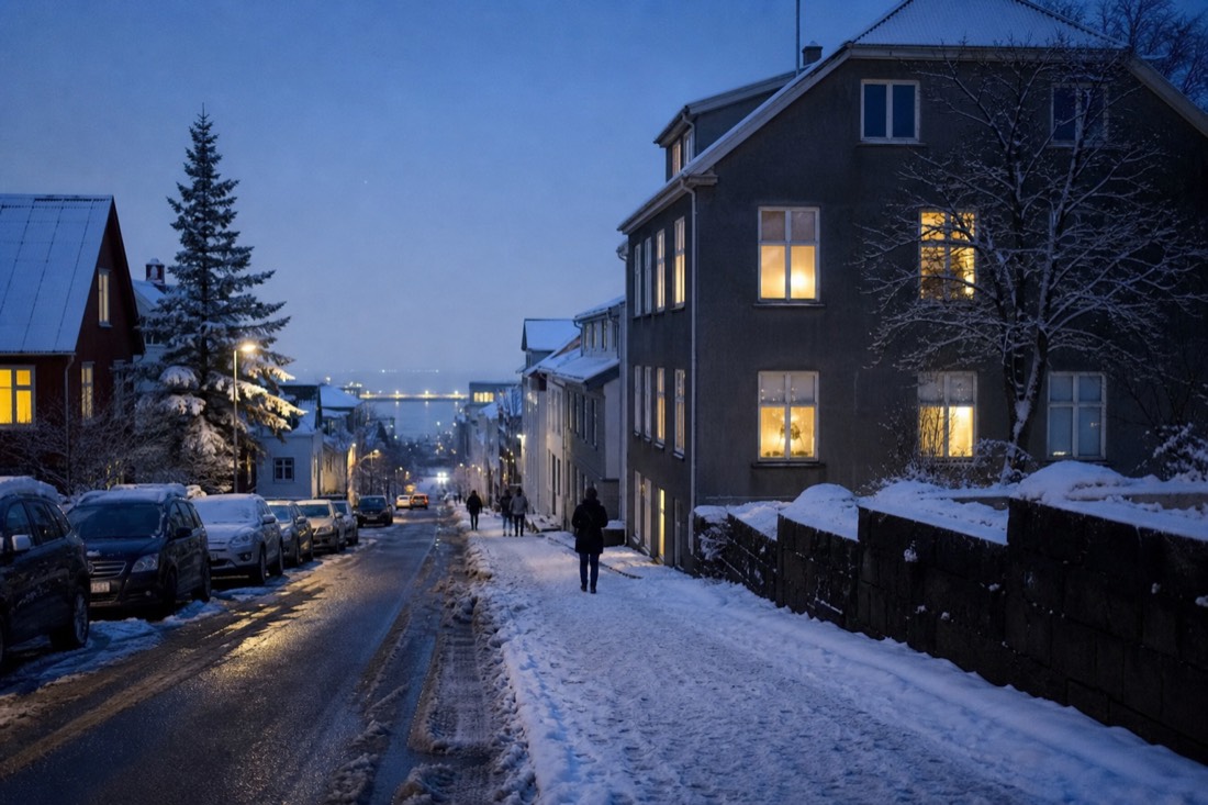 Snowy Reykjavik residential street at blue hour with warm light in the windows