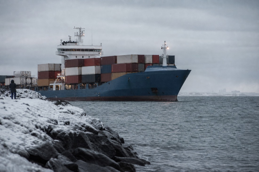Container ship at a snowy Icelandic quayside under flat grey winter light