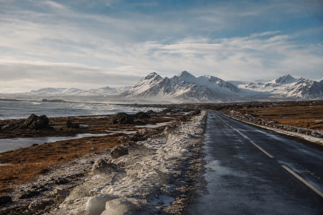 Bright March afternoon light on melting snow along the South Coast road, mountains clear