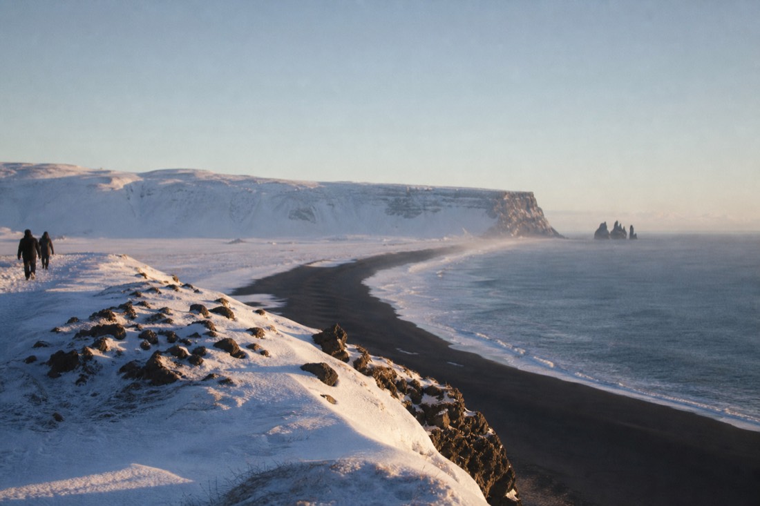 Late February afternoon light on the cliffs above Vik, long shadows stretched across snow