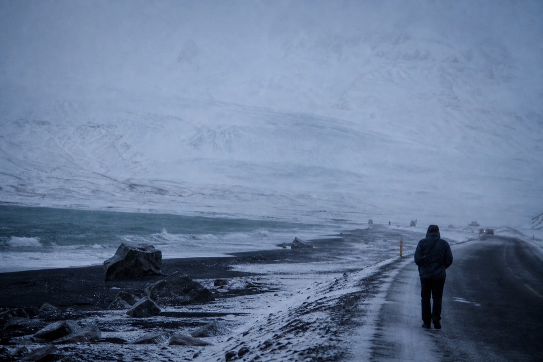 February squall driving snow across the South Coast road, low cloud hiding the glacier