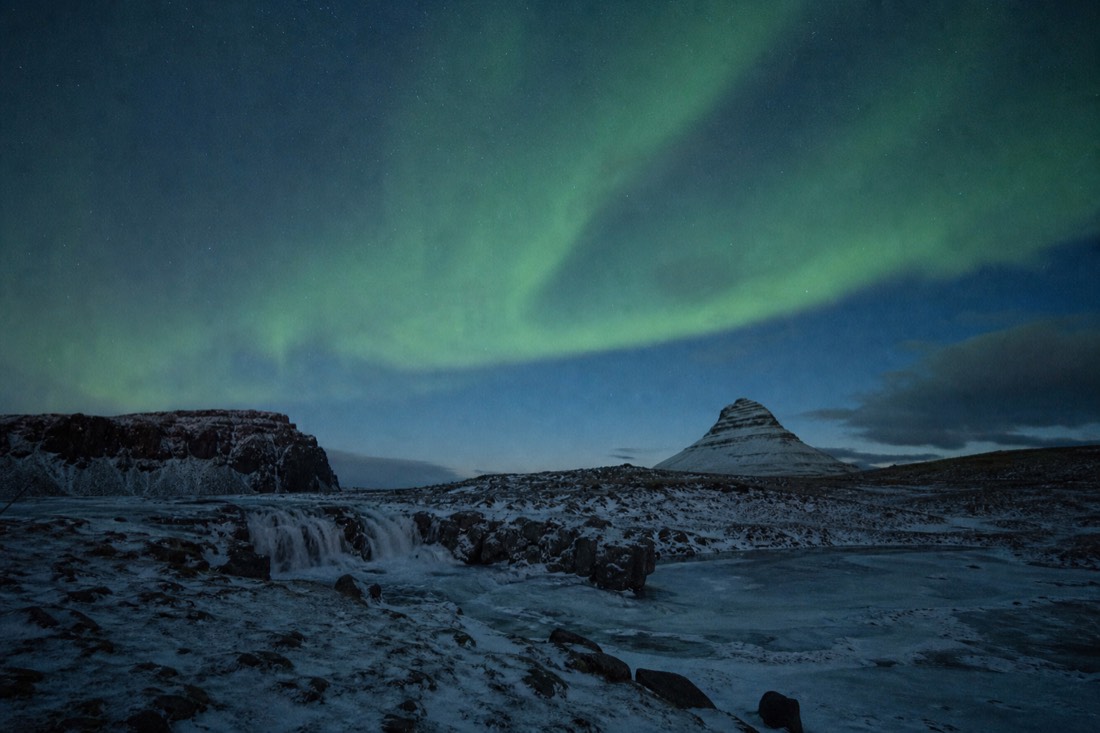 Aurora band over an empty frozen January landscape with no lights anywhere on the ground