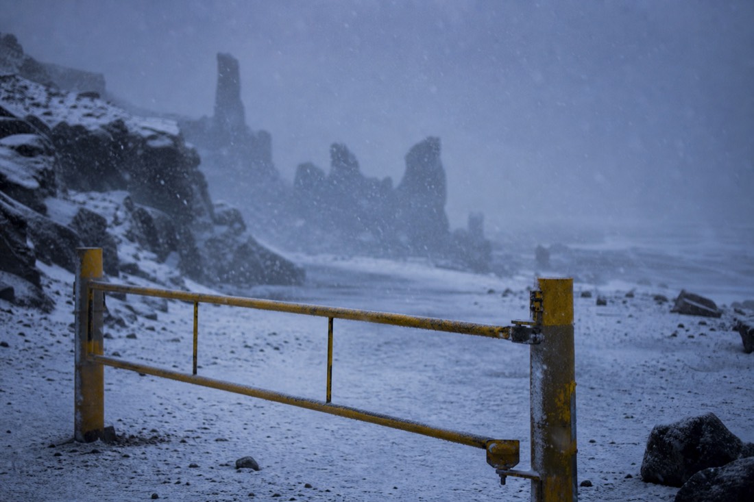 Falling snow across a closed road barrier on the South Coast, visibility down to a few metres