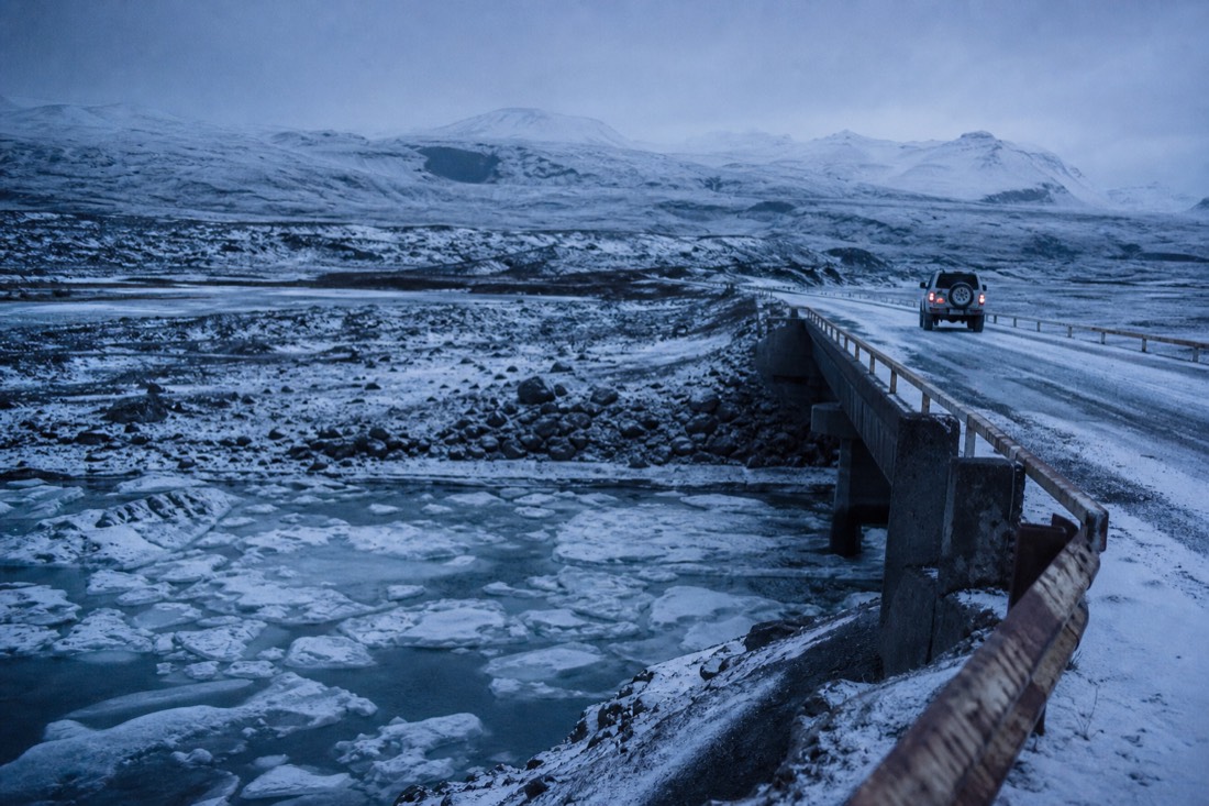 Single-lane bridge over a frozen glacial river in south Iceland under flat overcast light