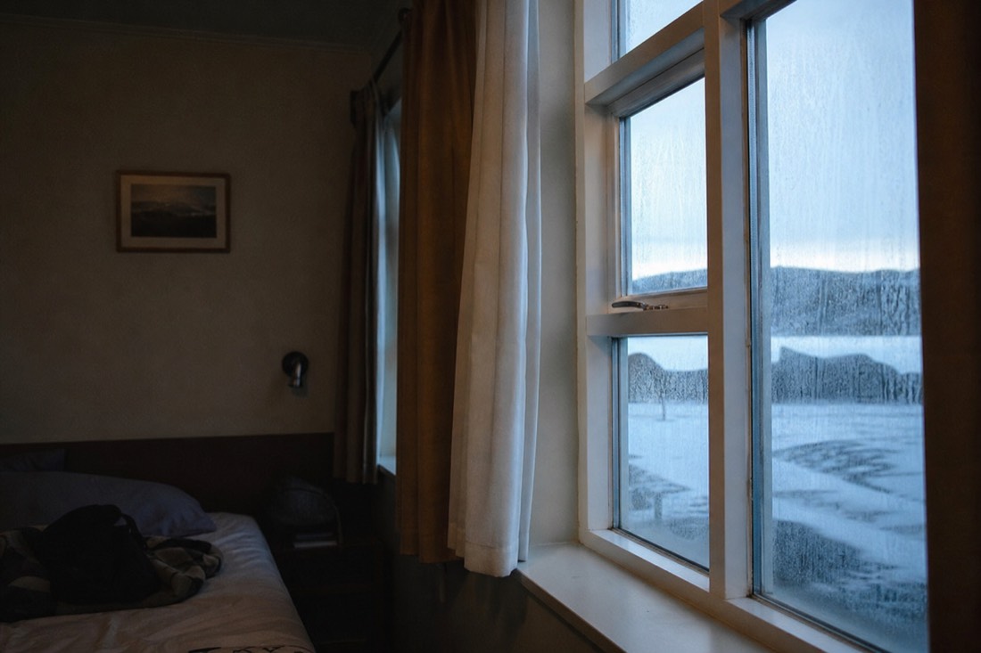 Interior window light in an Icelandic guesthouse room, frost on the glass and snow outside