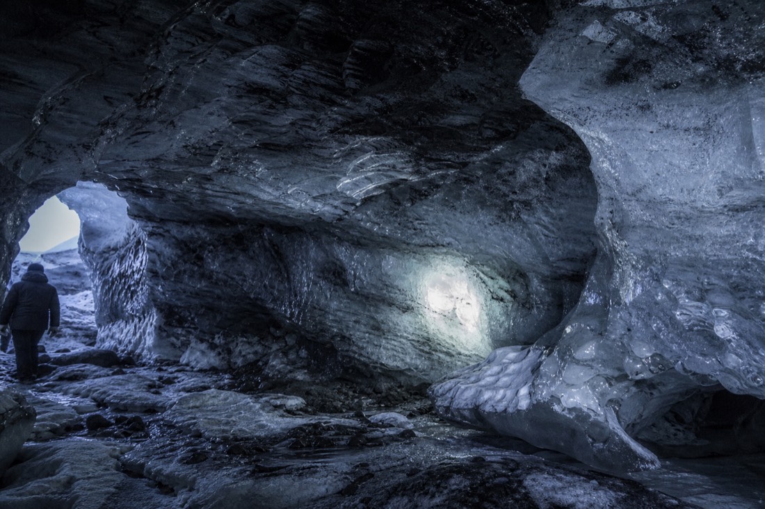 Ash-streaked ice walls of the Katla cave under Myrdalsjokull lit by a headtorch beam